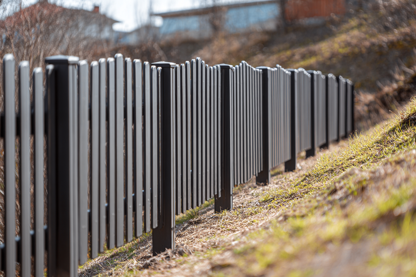 Ogrodzenie na skarpie lub nierównym terenie – jak to zrobić i jakie sztachety wybrać?